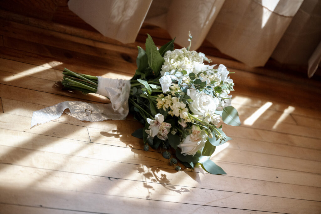 Classic white rose bridal bouquet with soft greenery accents.