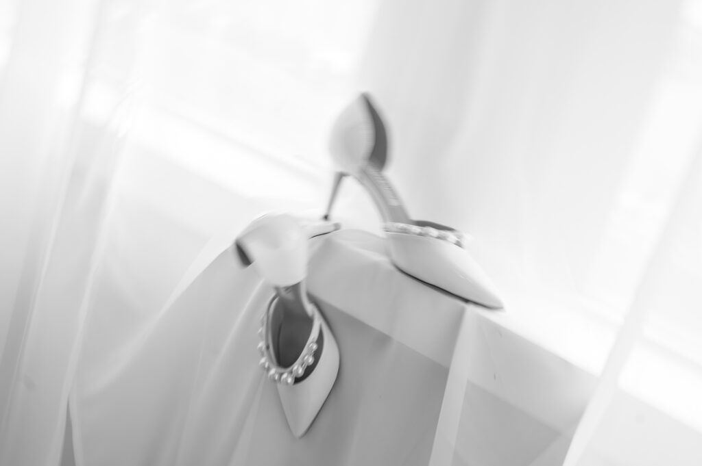 Jimmy Choo wedding shoes photographed in a window with soft natural light.