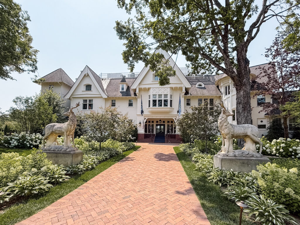 Hidden garden ceremony space at The Inn at Stonecliffe Mackinac Island wedding venue with wooden chairs and lush greenery. Wedding photographer