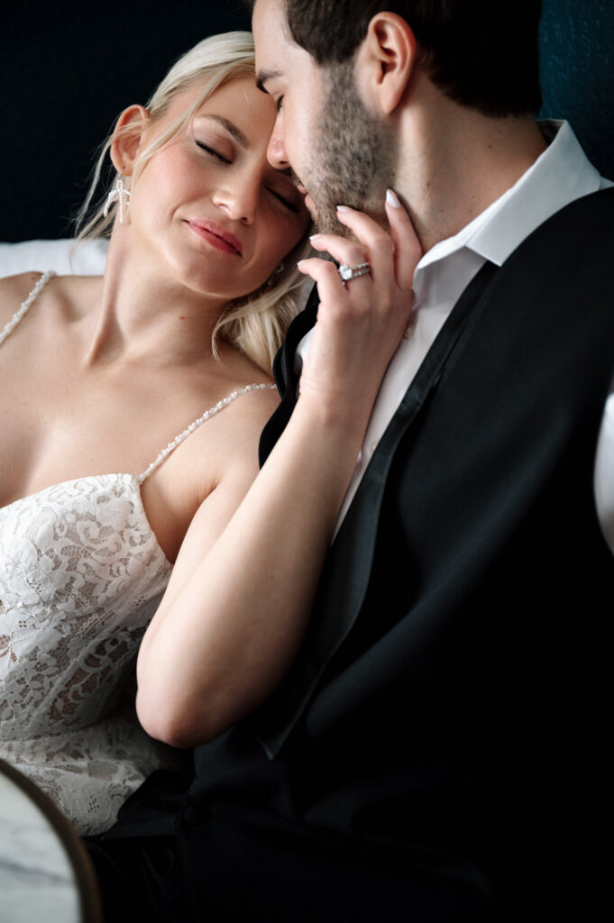 Intimate portrait of bride and groom embracing, captured in soft light with an elegant, editorial feel