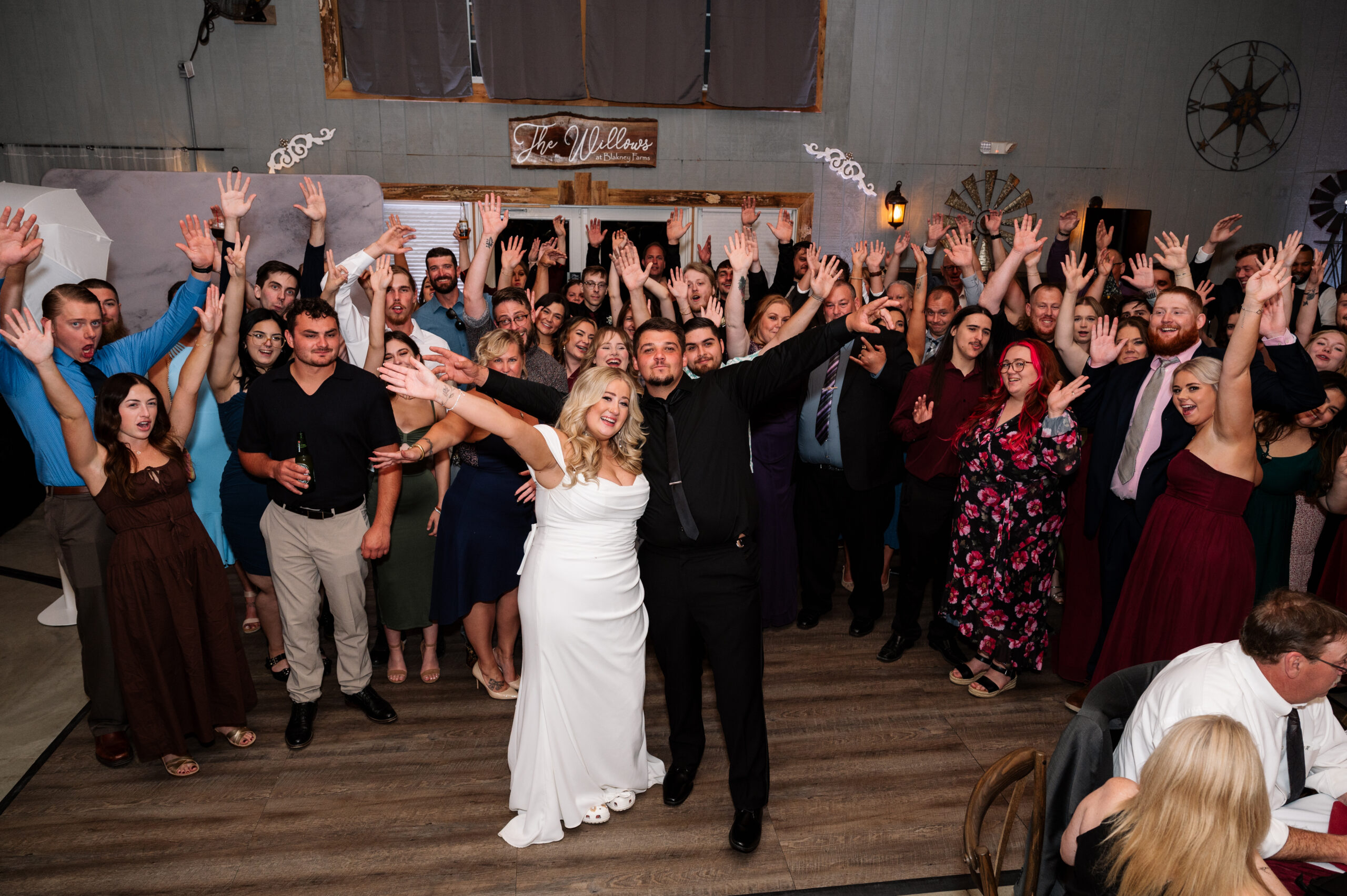 Wedding guests with bride and groom on the dance floor at the wedding reception